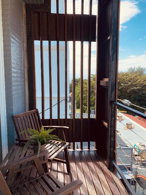 a wooden porch with a bench and a view of the ocean at The Deer Head Inn in Kenting