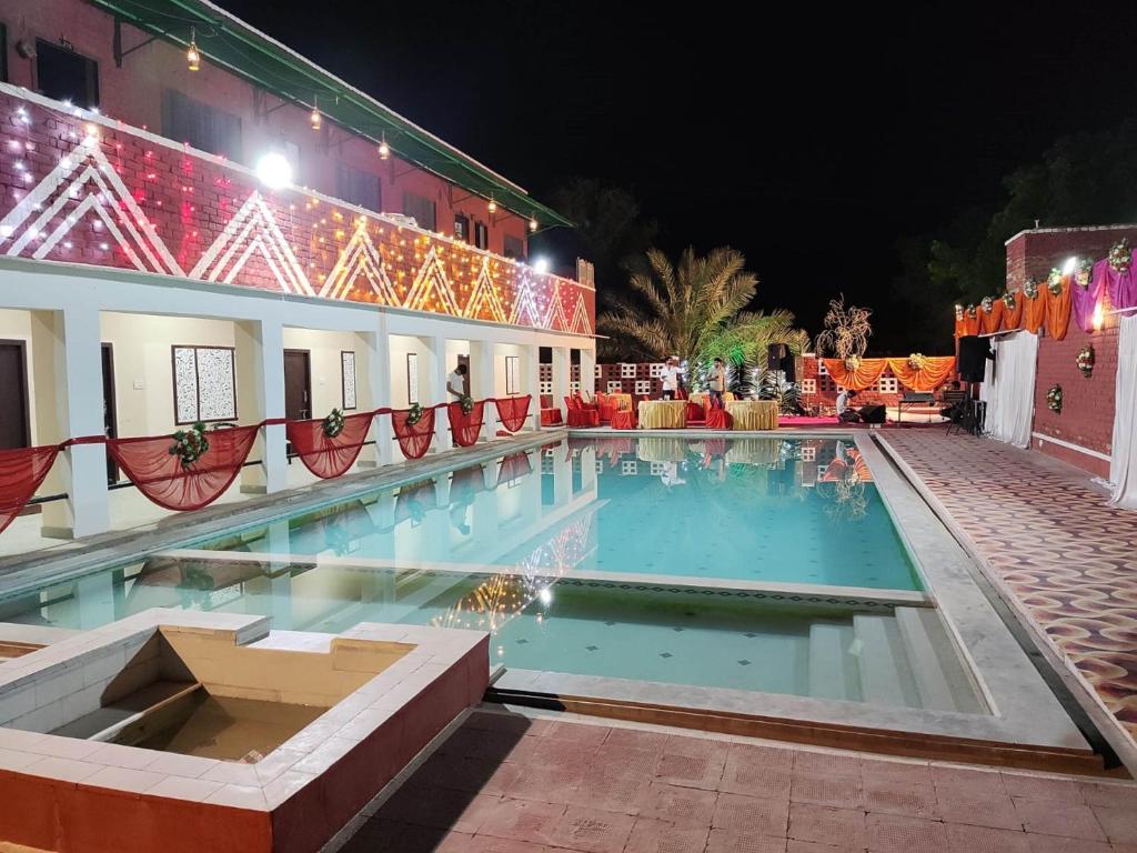 una piscina por la noche con luces de Navidad en Thar Exotica Spa & Resort en Bikaner
