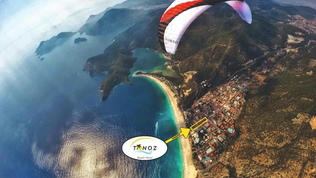 a paraglider is flying over a body of water at Tonoz Beach Hotel in Oludeniz