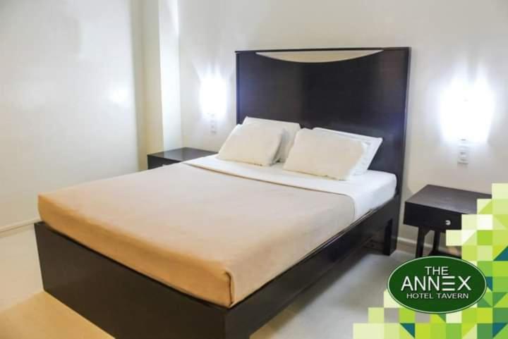 uma cama com duas almofadas num quarto em Annex Hotel Tavern em Surigao
