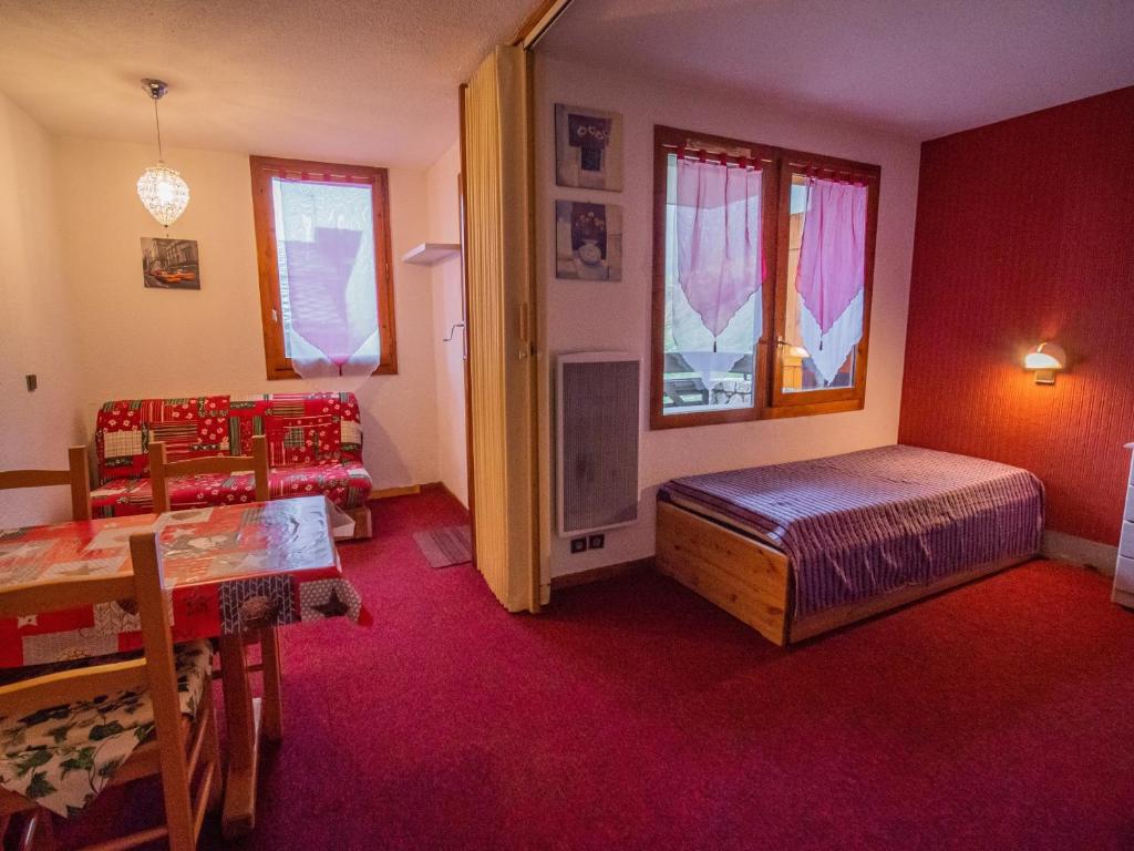 a bedroom with a bed and a table and chairs at Appartement Valmorel, 1 pièce, 4 personnes - FR-1-356-337 in Valmorel