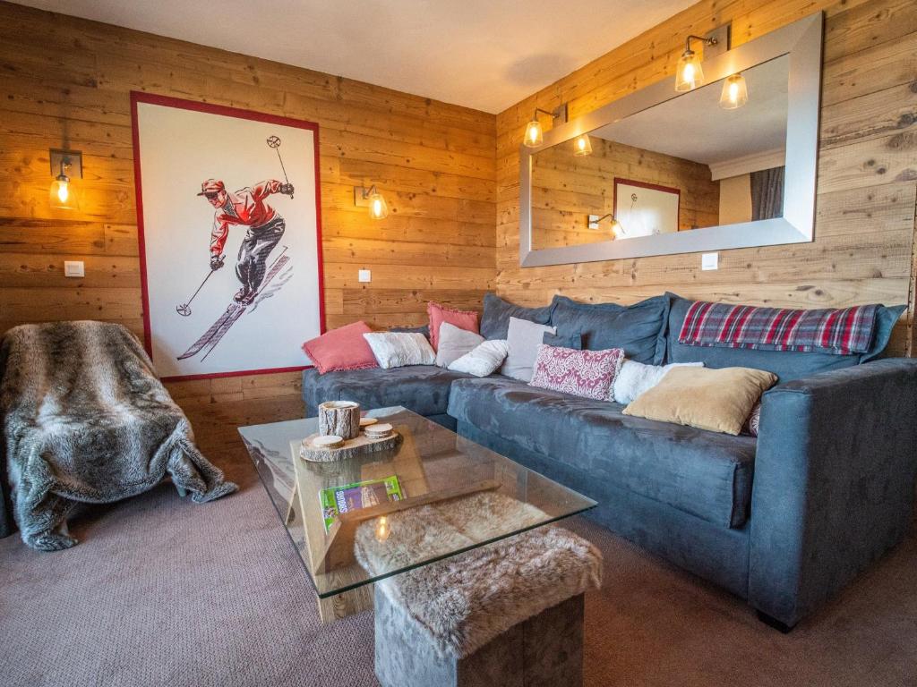 a living room with a blue couch and wooden walls at Appartement Valmorel, 3 pièces, 4 personnes - FR-1-356-324 in Valmorel