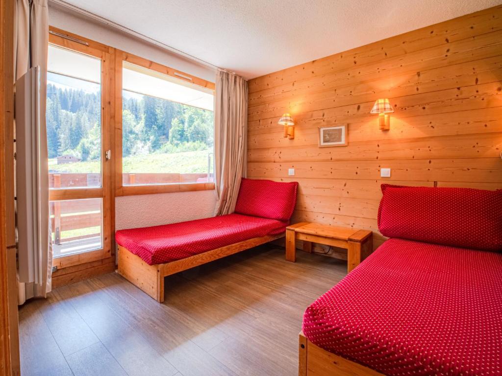 ヴァルモレルにあるAppartement Valmorel, 1 pièce, 4 personnes - FR-1-356-322の赤いベンチと窓が備わる客室です。