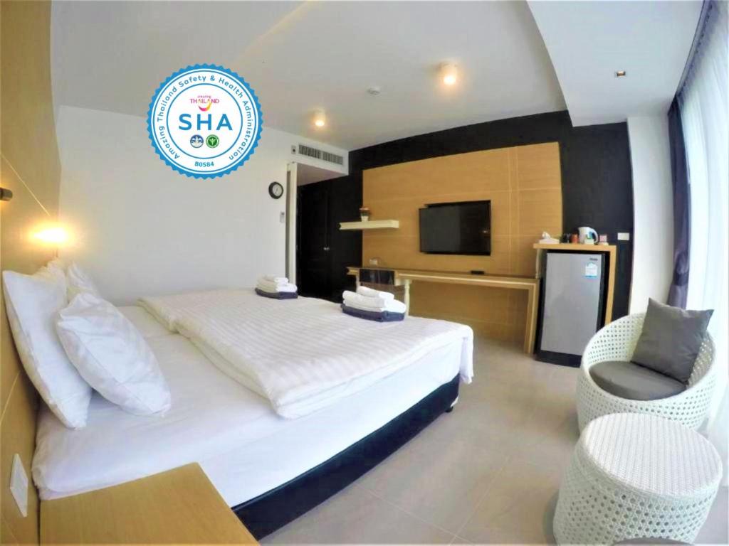 una habitación de hotel con una cama y un televisor en Vivace Hotel, en Kamala Beach