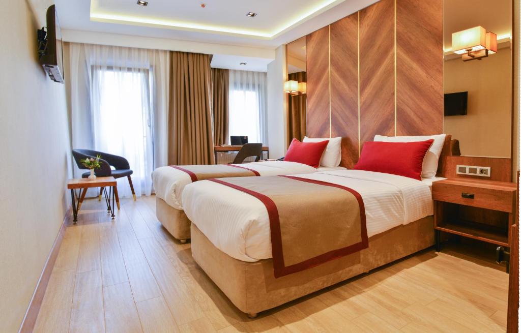 Cette chambre comprend deux lits et un bureau. dans l'établissement Celine Hotel Taxim, à Istanbul