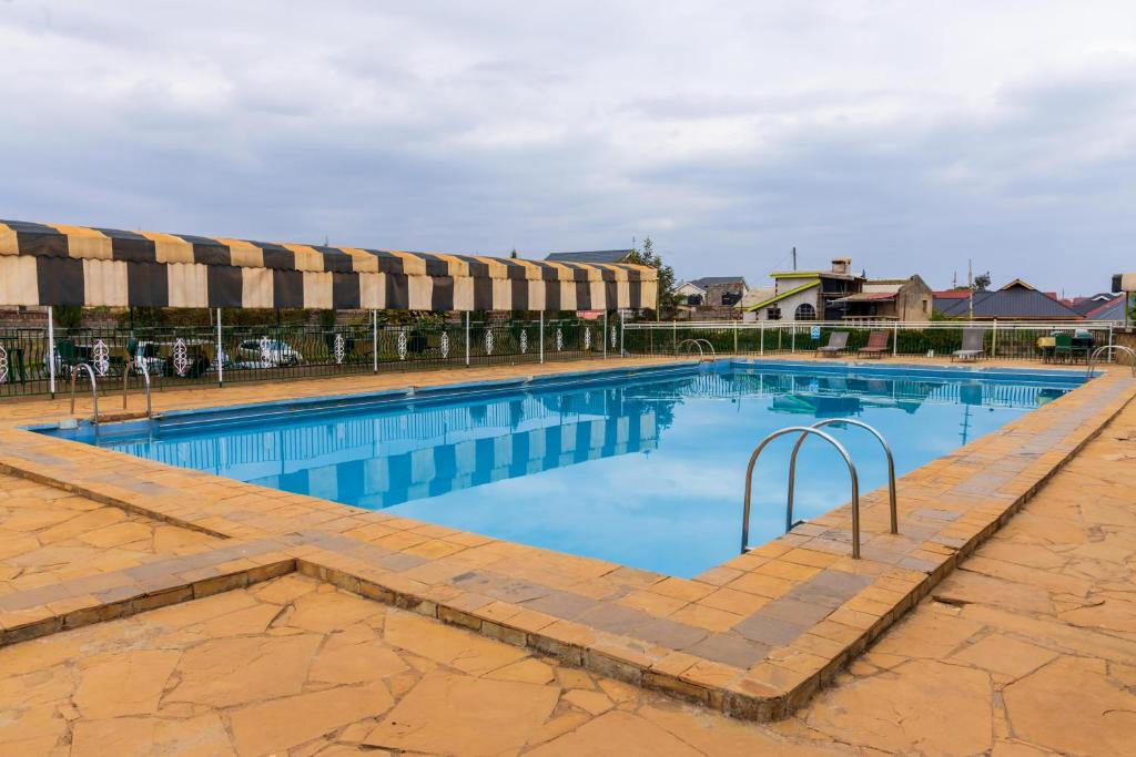 een groot zwembad met blauw water bij Olive Green Garden Resort in Nairobi