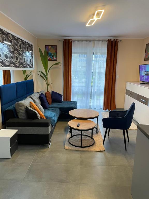 een woonkamer met een blauwe bank en een tafel bij Apartament Nad Nielbą in Wągrowiec