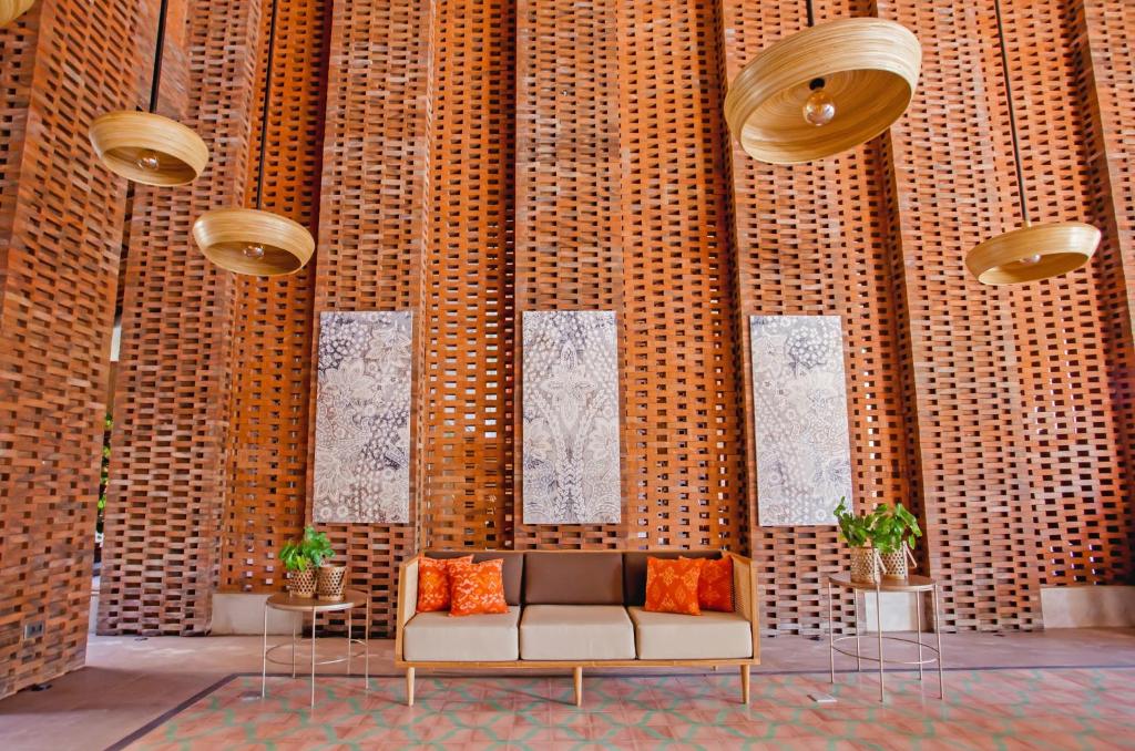 a couch sitting in a room with a wall at Amnaya Resort Nusa Dua in Nusa Dua