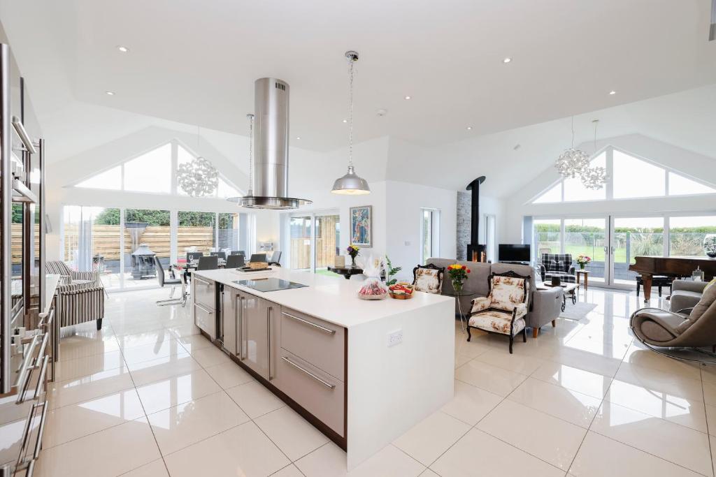 uma cozinha e sala de estar com paredes e janelas brancas em Luxurious & Spacious 3BR House with a Hot Tub em Kinross