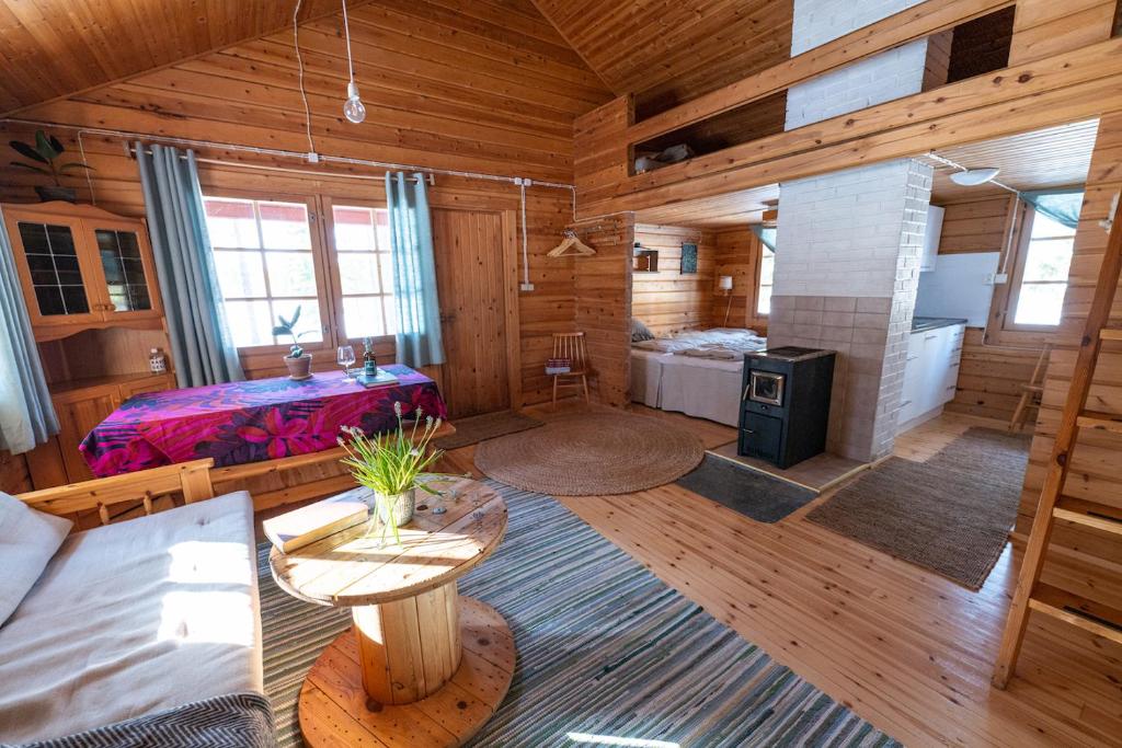 ein großes Wohnzimmer mit einem Bett und einem Kamin in der Unterkunft Metsä Kolo in Saariharju