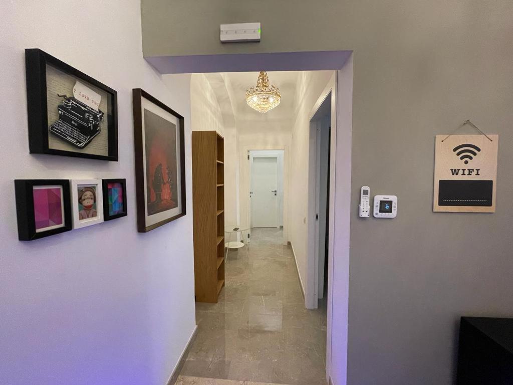 un corridoio con una parete viola con delle foto sopra di Domus Enea - Colosseo Termini a Roma