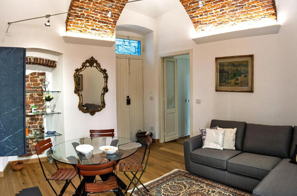 sala de estar con sofá y mesa de cristal en Casa del Conte Massimiliano Roero, en Cuneo