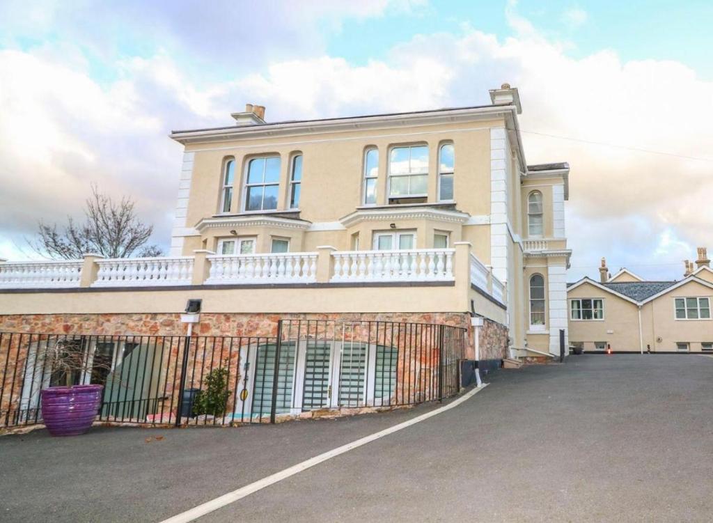 a large house with a fence in front of it at Modern 2 bed apartment with sea views in Torquay