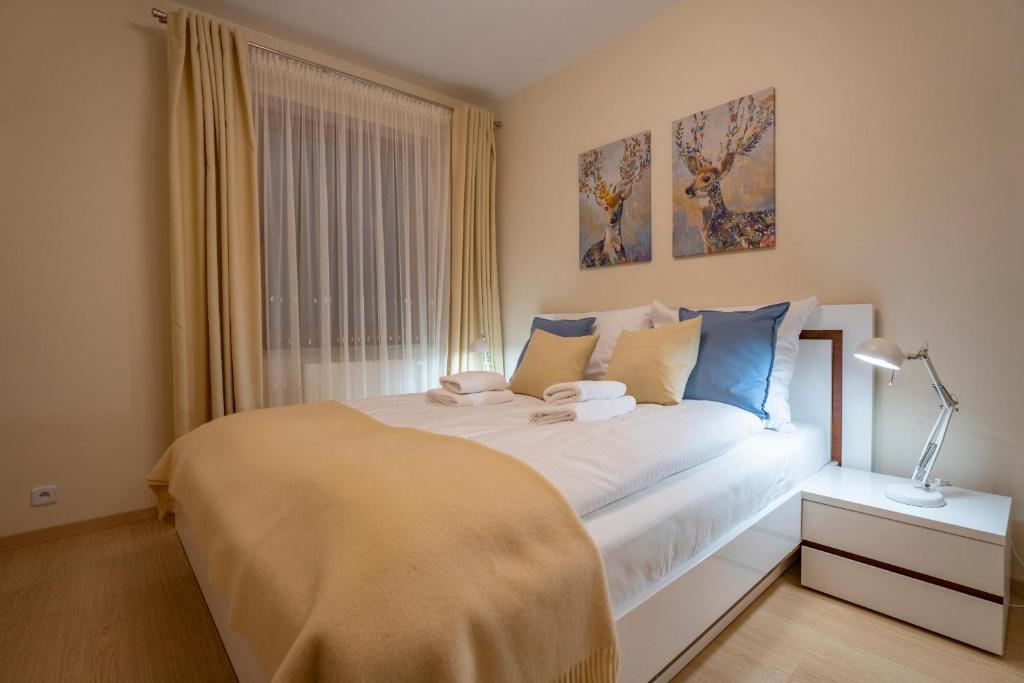sypialnia z dużym łóżkiem i oknem w obiekcie RentPlanet - Apartamenty Szrenica w Szklarskiej Porębie