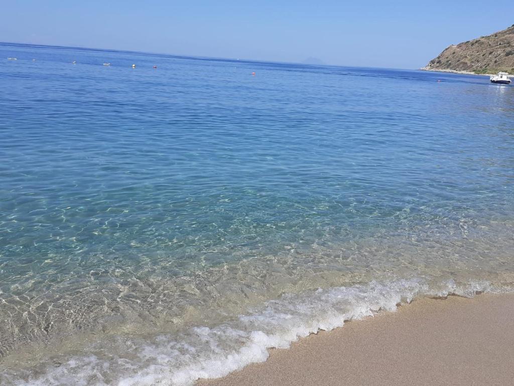 una playa con el océano y un barco en el agua en Acqua Marina, en Nicotera Marina