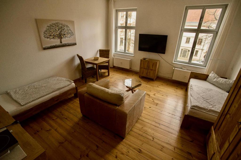 ein Wohnzimmer mit einem Sofa und einem TV in der Unterkunft Fewo auf der Dominsel-DOMLINDEN in Brandenburg an der Havel