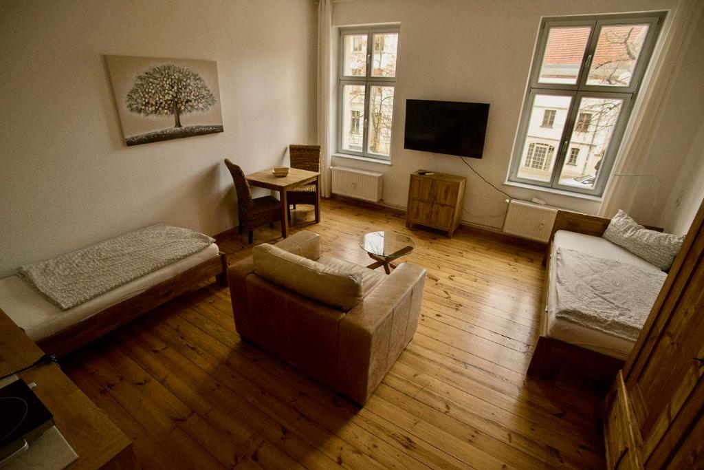 a living room with a couch and a tv at Fewo auf der Dominsel-DOMLINDEN in Brandenburg an der Havel