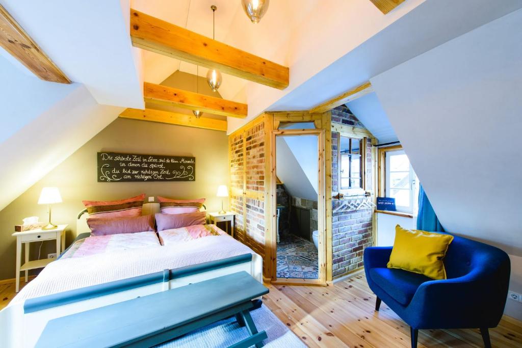 ein Schlafzimmer mit einem Bett und einem blauen Stuhl in der Unterkunft Kramerstube in Quedlinburg