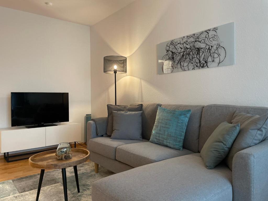 a living room with a couch and a flat screen tv at Apartment Modern Stylish-kitchen,BLK near Fair-Bosch Forschung-Zentrum in Renningen