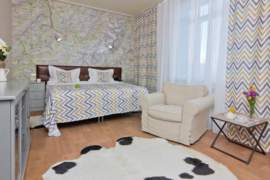 1 dormitorio con 1 cama y 1 silla en Аврора Wellness & SPA Hotel, en Chelyabinsk