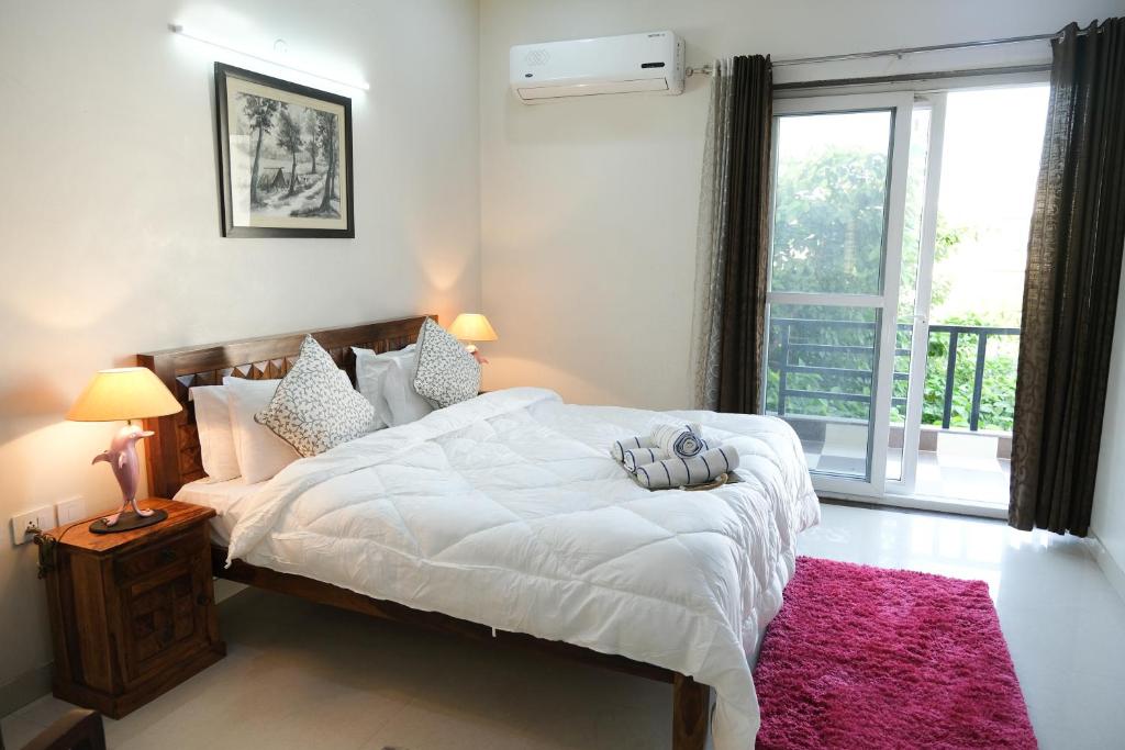 Un dormitorio con una gran cama blanca y una ventana en Lime Tree Luxurious 3BHK Serviced Apartment Near Medanta, en Gurgaon