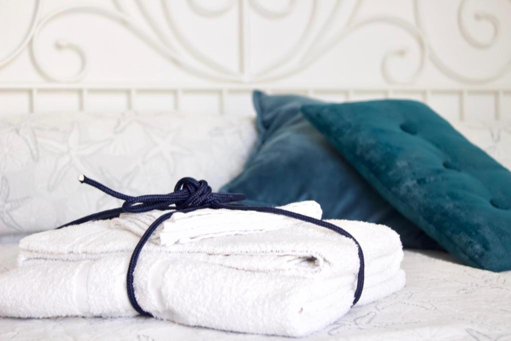 uma pilha de toalhas numa cama com almofadas em Uno Scorcio di Blu em Rimini