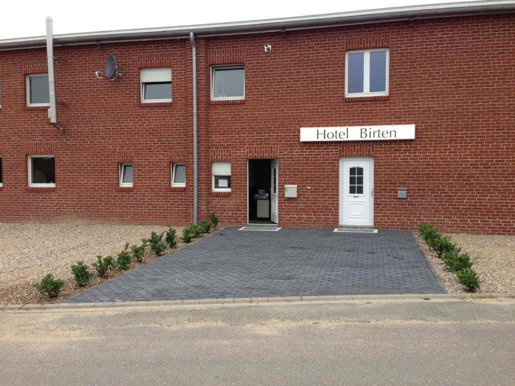 un edificio de ladrillo rojo con puerta blanca en Hotel Birten, en Xanten