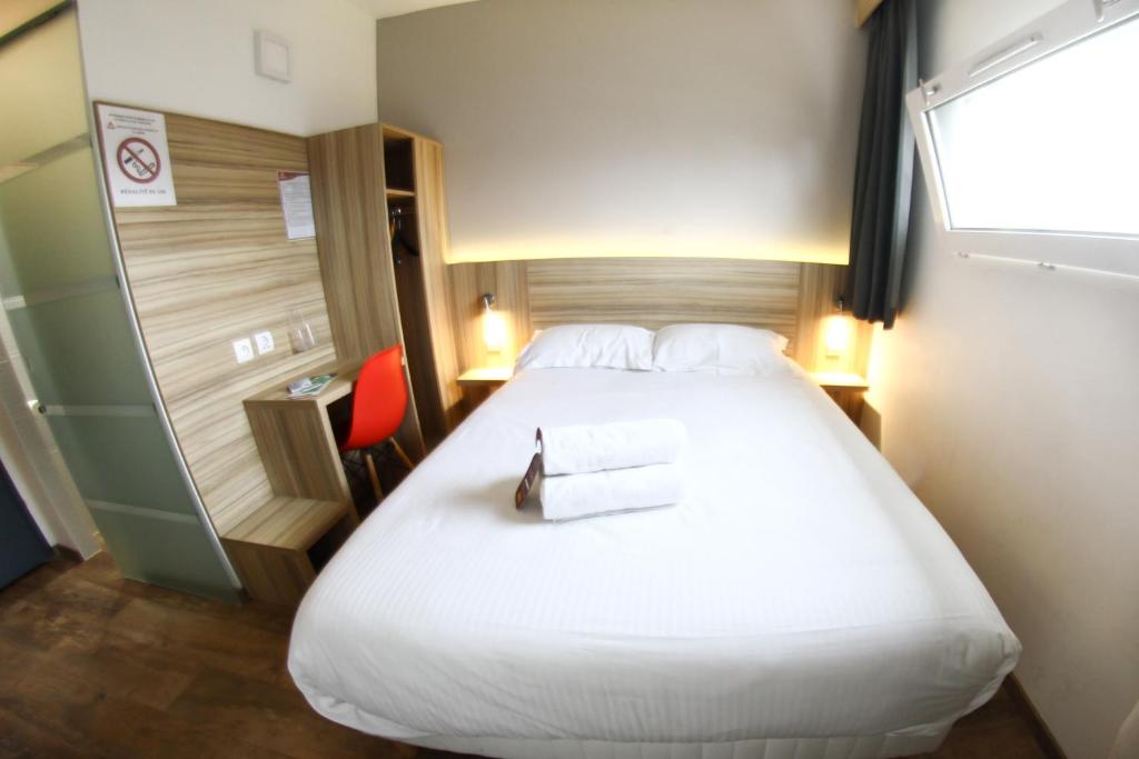 een hotelkamer met een groot bed en een rode stoel bij Best Hotel Bordeaux Sud in Villenave-dʼOrnon