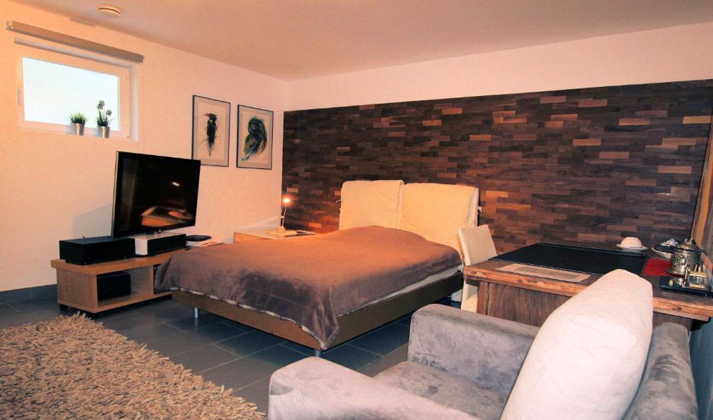 a bedroom with a bed and a couch and a tv at Großes Privatzimmer in Messenähe in Hannover