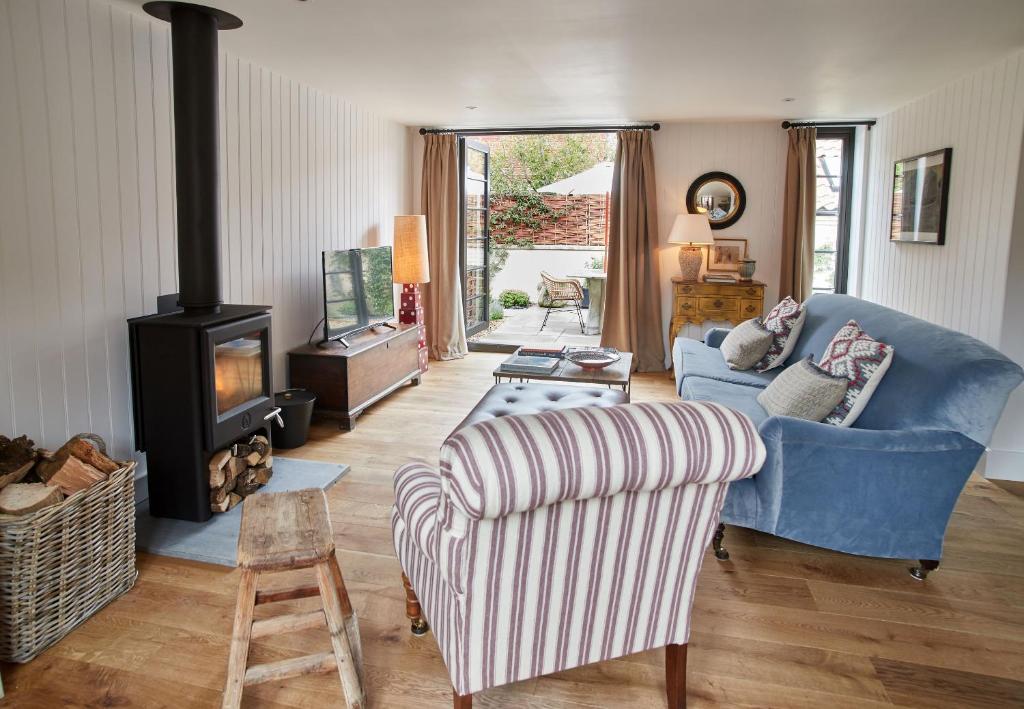 a living room with a couch and a wood stove at The Workshop in Fakenham