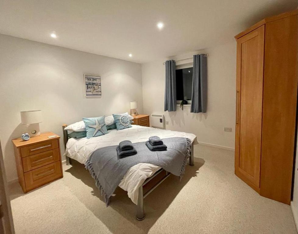1 dormitorio con 1 cama, vestidor y ventana en Sea view apartment at the beach!, en Llanelli