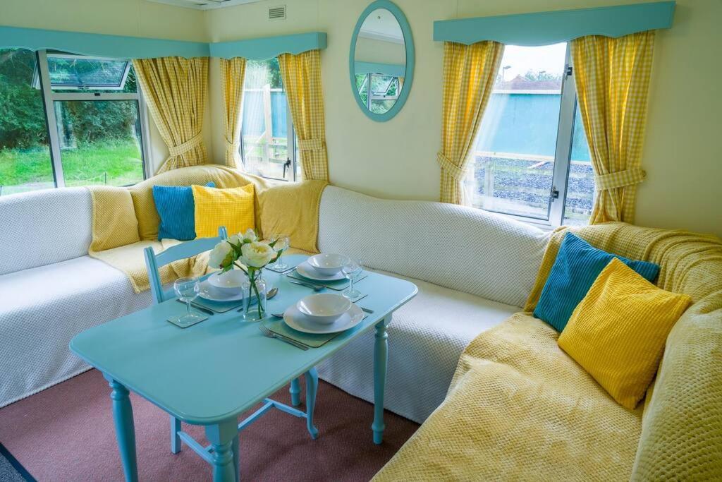 uma sala de estar com uma mesa e um sofá em Wind In The Willows: Sleeps 4, Kitchen, bathroom, lounge, WIFI em Napton on the Hill