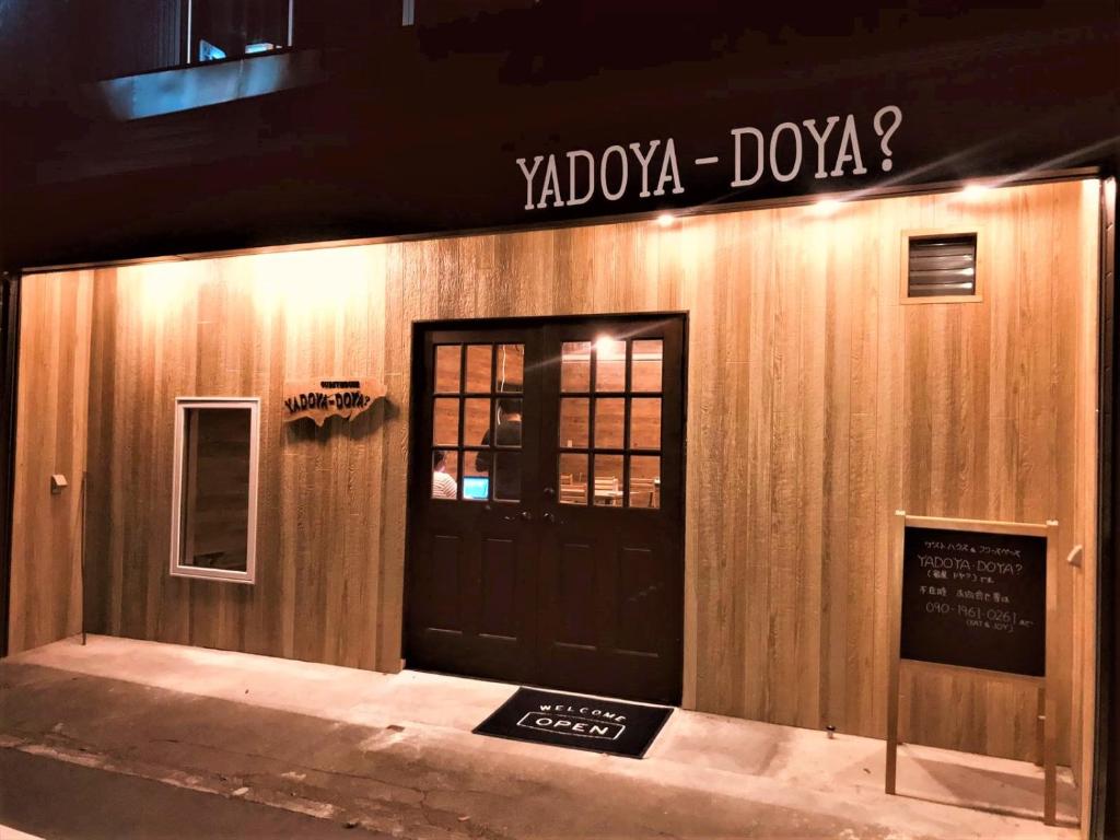un edificio con una puerta y una señal en él en 宿屋DOYA, en Miyada
