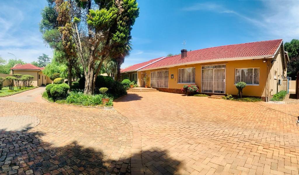 a house with a red roof and a brick driveway at Casas Navio Guest House in Johannesburg