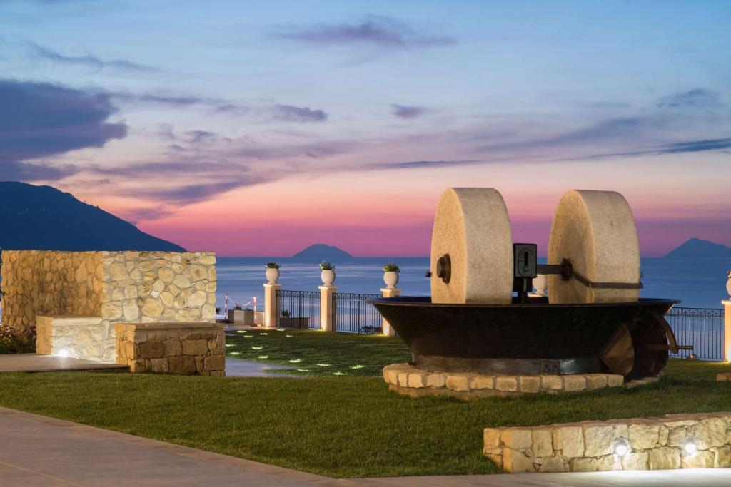 ein Denkmal vor dem Meer bei Sonnenuntergang in der Unterkunft Best Western Plus Hotel Terre di Eolo in Patti