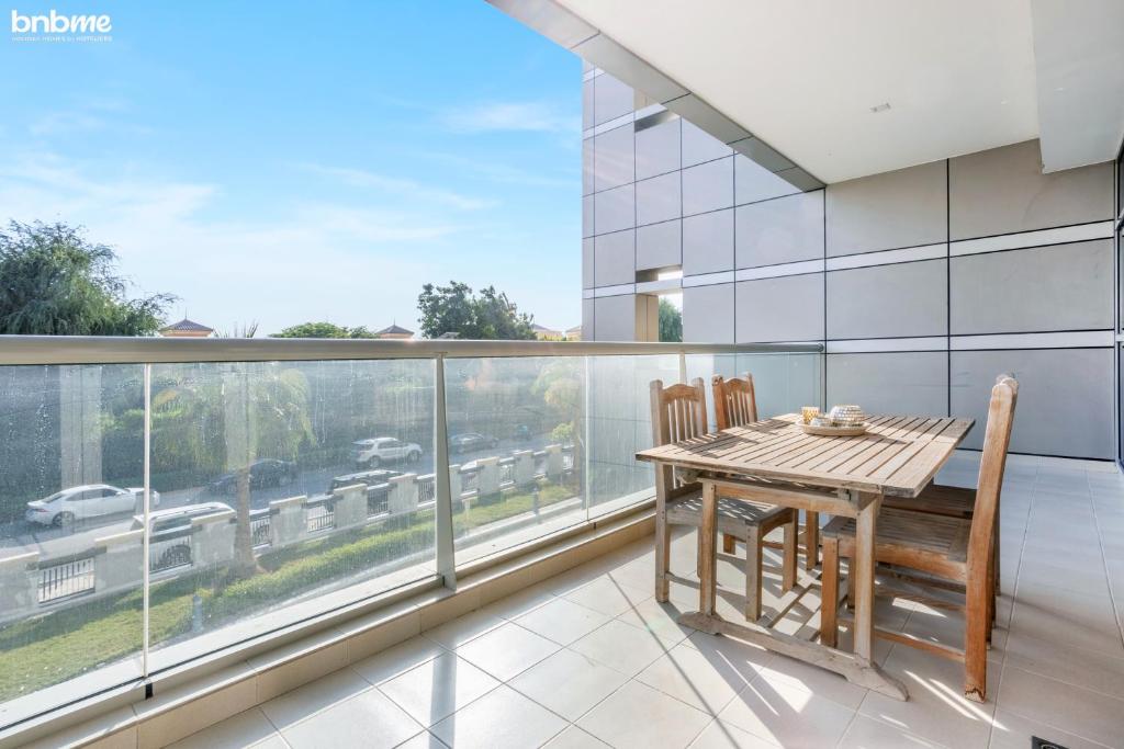 ein Esszimmer mit einem Tisch und Stühlen auf dem Balkon in der Unterkunft bnbmehomes - Great Value Spacious Apartment w Moden Furniture - 103 in Dubai