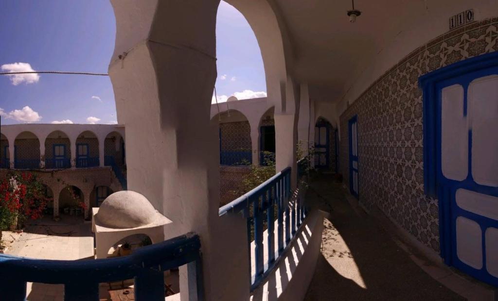 a building with a staircase and an archway on it at Hôtel Sindbad in Houmt Souk