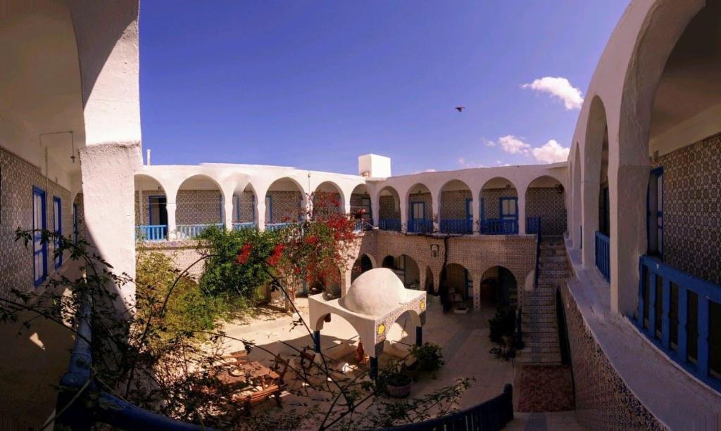 a view of a courtyard with a chair in a building at Hôtel Sindbad in Houmt Souk