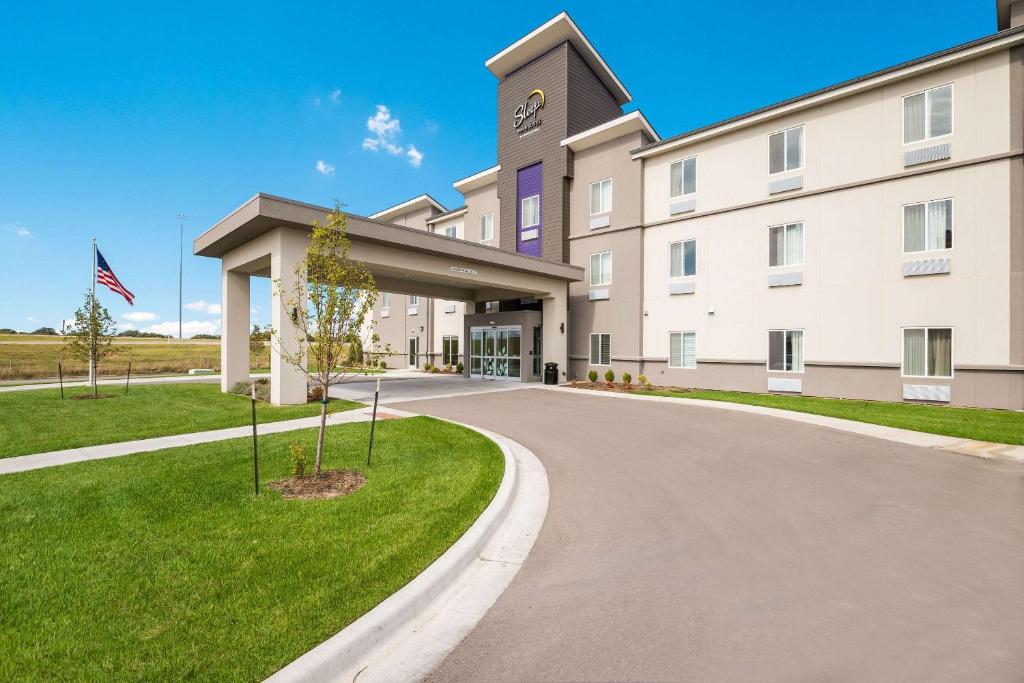 un grand bâtiment blanc avec une tour d'horloge dans l'établissement Sleep Inn & Suites Park City-Wichita North, à Park City