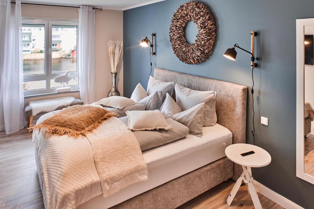 um quarto com uma cama com almofadas e um espelho em Luxus Ferienwohnung Beach Style, traumhafter Seeblick em Fulda