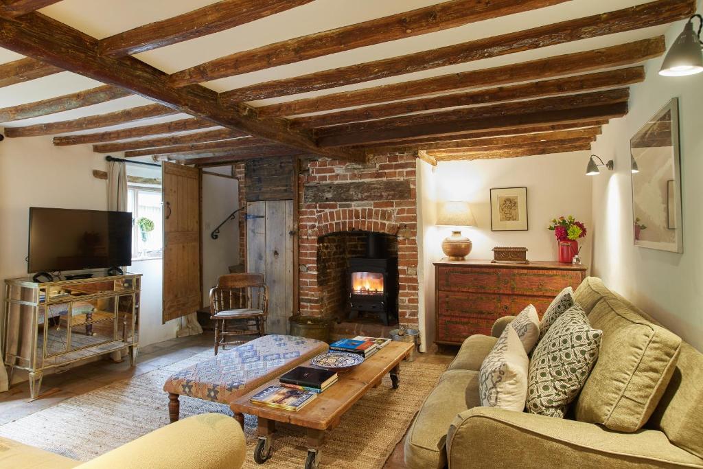 a living room with a couch and a fireplace at Rock Cottage in East Rudham