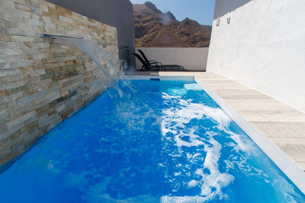 een zwembad met blauw water in een gebouw bij Casa nuestra in Agaete