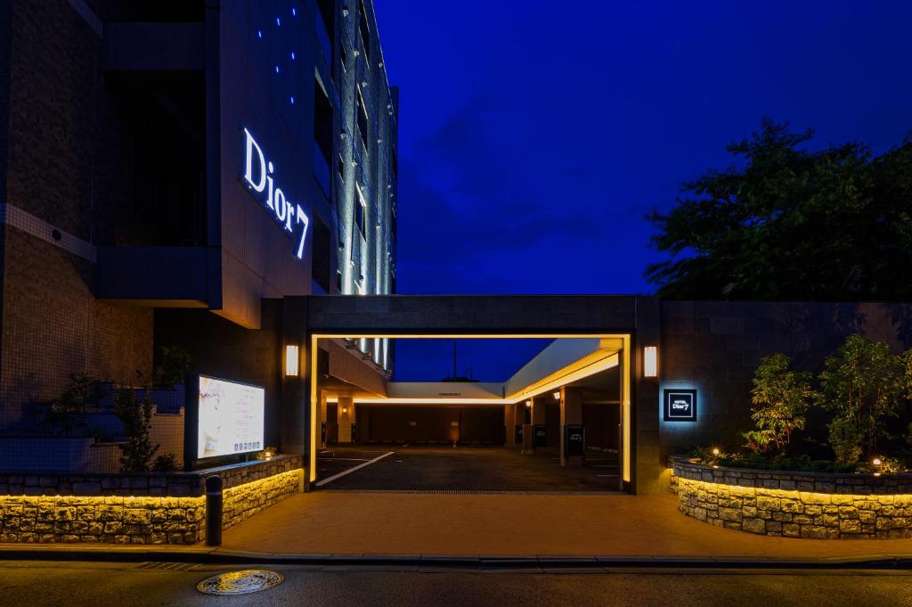 HOTEL Dior7つくば في تسوشيورا: مبنى مع باب مفتوح في الليل