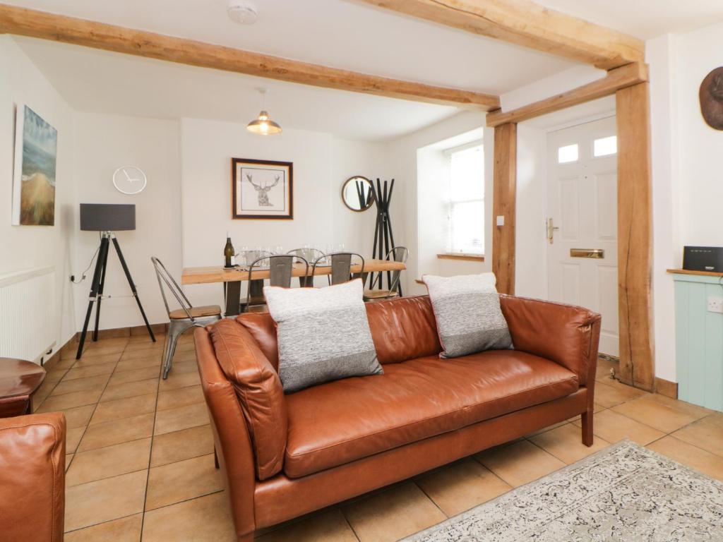 sala de estar con sofá de cuero marrón en The Yellow House, 13 King Street en Dawlish