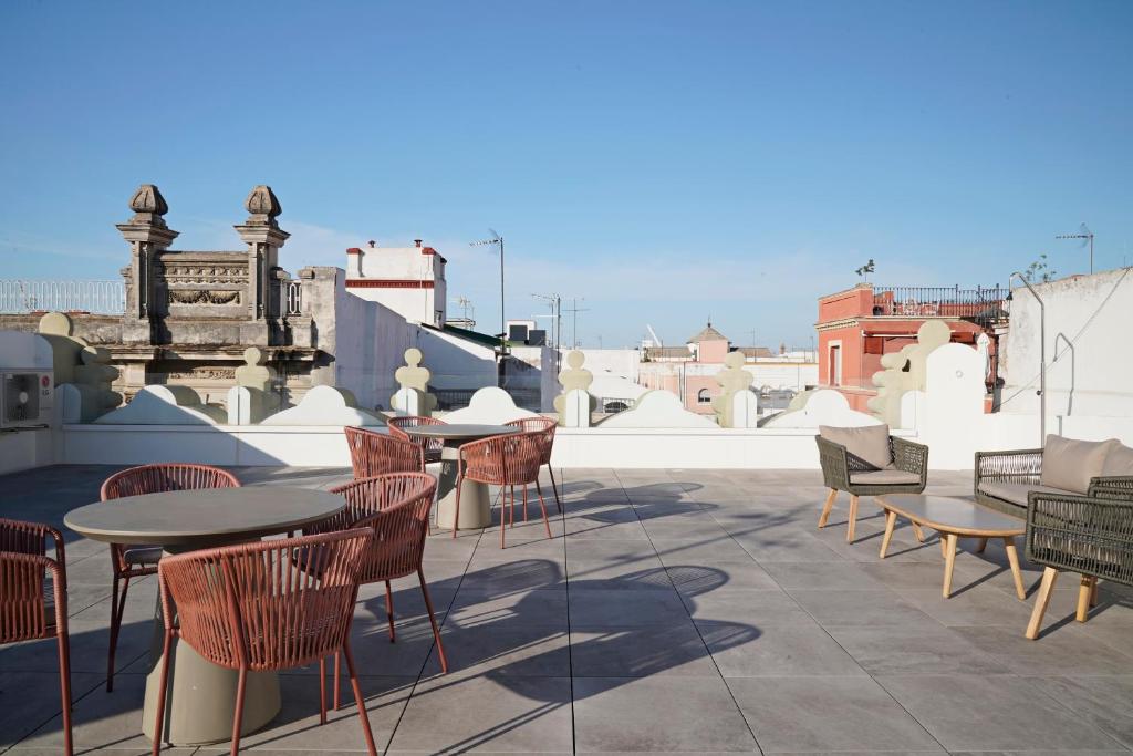 un patio con mesas y sillas en la azotea en numa I Solea Apartments, en Sevilla