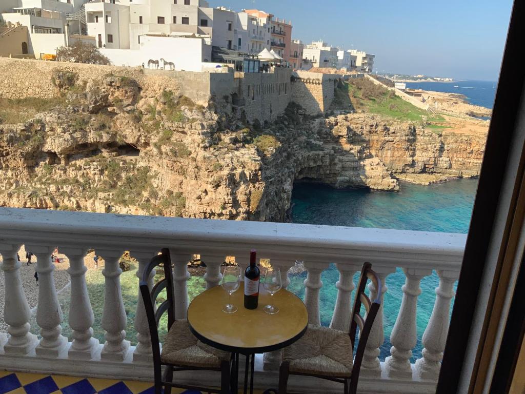 a table with a bottle of wine on a balcony at Suite a mare - Casa della Poetessa in Polignano a Mare