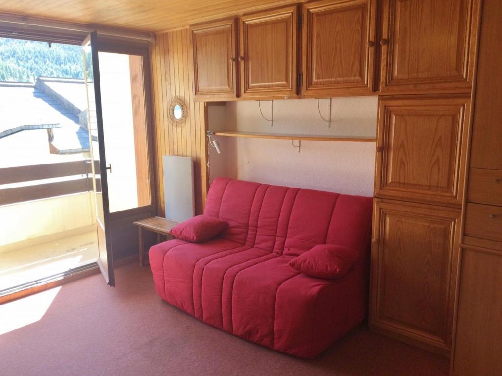 a red couch in a room with a cabinet at Studio Montgenèvre, 1 pièce, 4 personnes - FR-1-445-90 in Montgenèvre