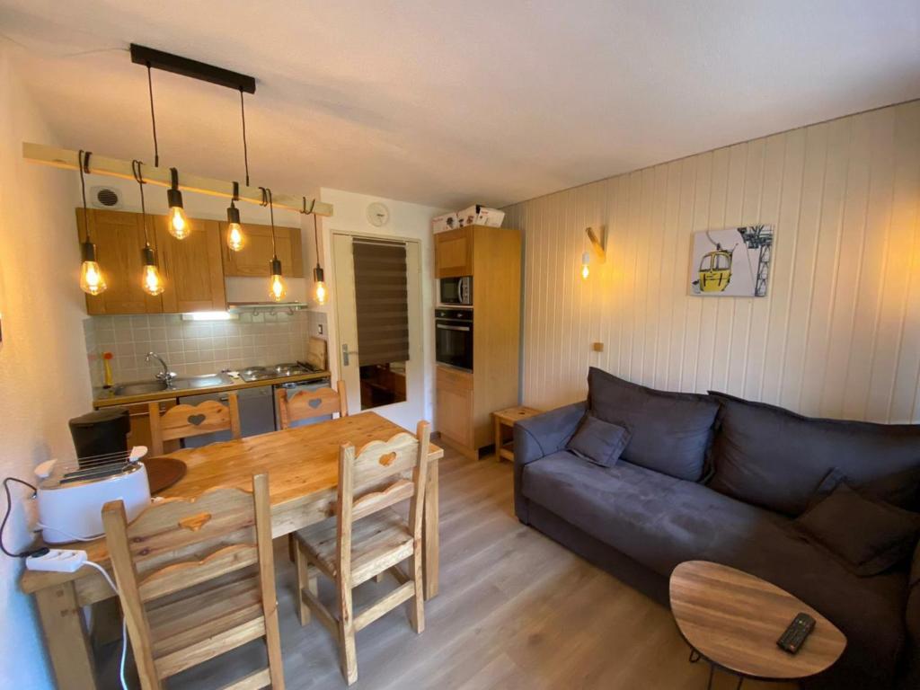 Appartement Montgenèvre, 2 pièces, 4 personnes - FR-1-445-159 في مونجينيفر: غرفة معيشة مع أريكة وطاولة خشبية