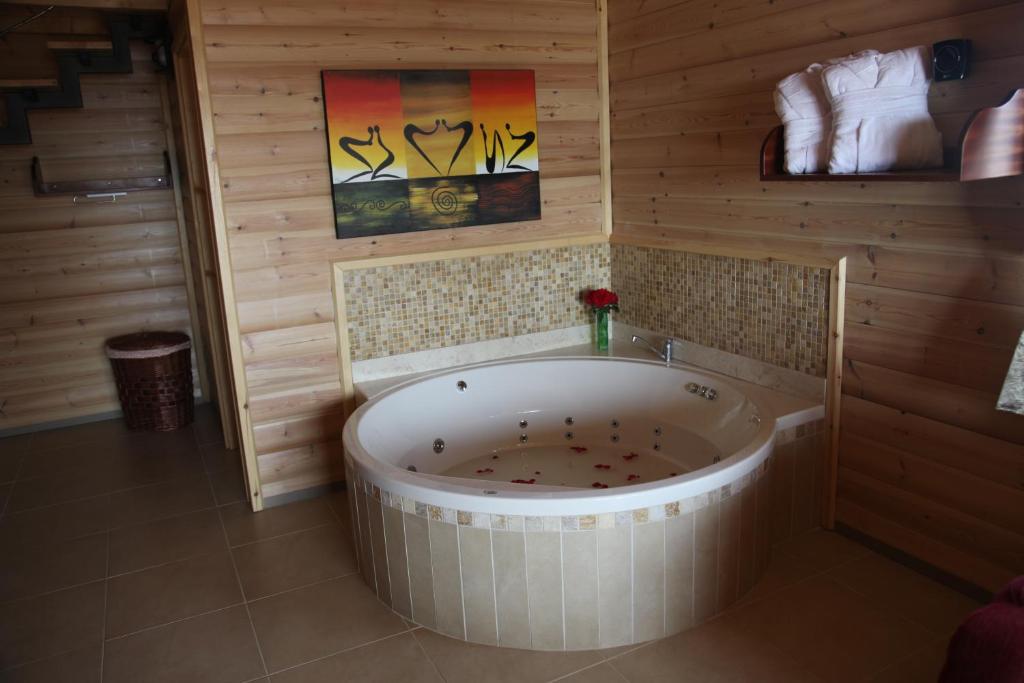 a bathroom with a large tub in a room at Be-Taam Ahava Suites in Bruchim Qela' Alon