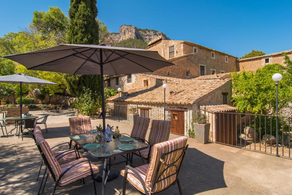 eine Terrasse mit einem Tisch mit Stühlen und einem Sonnenschirm in der Unterkunft Agroturismo Son Penyaflor in Alaró